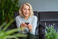 Serious woman attending a phone call sitting on a sofa in the living room at home. Royalty Free Stock Photo