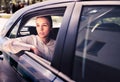 Serious woman in car. Sad, upset or tired taxi passenger. Cool elegant business lady sitting on the back seat looking out.