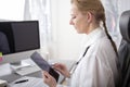 Serious Woman Clinician Using Tablet at her Office