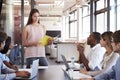 Serious woman with document stands addressing team meeting Royalty Free Stock Photo