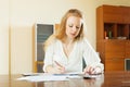 Serious woman fills in financial documents