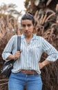 Serious woman holding her bag pack with disapproving expression in her face and arm in her waist Royalty Free Stock Photo