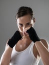 Serious woman, portrait and boxer with fist ready for fight, workout or exercise in fitness on a gray studio background Royalty Free Stock Photo
