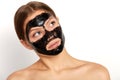 Serious woman with purifying black mask on her face looking up