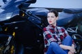 Serious woman in a shirt on a motorcycle background, smoothed hair and red lipstick Royalty Free Stock Photo