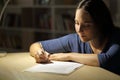 Woman signs contract at night at home Royalty Free Stock Photo