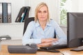 Serious woman sitting behind a desk Royalty Free Stock Photo