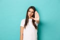 Serious woman in white t-shirt telling to stop, saying no, stretching one hand to prohibit something bad, standing over