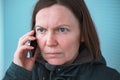 Serious worried woman talking on mobile phone on street Royalty Free Stock Photo