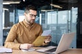 A serious and worried young businessman working in the office holds a letter, documents. got bad news. Saddenedly reads Royalty Free Stock Photo