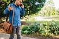 Serious young adult entrepreneur or businessman, discussing something with his coworker over the phone Royalty Free Stock Photo