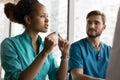 Serious young African American doctor woman speaking to colleagues Royalty Free Stock Photo