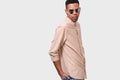 Serious young African American man wearing round mirror sunglasses and casual beige shirt, looking to the camera and posing over Royalty Free Stock Photo