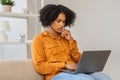 Serious young African American woman with curly hair focused on her laptop screen Royalty Free Stock Photo