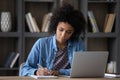 Serious young African Black student girl writing notes at laptop Royalty Free Stock Photo