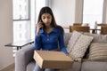 Serious young Asian consumer woman holding cardboard box with purchase Royalty Free Stock Photo
