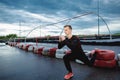 Serious young athlete makes lunges outdoors. The man warms up before jogging in the morning Royalty Free Stock Photo