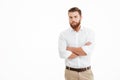 Serious young bearded man standing over white wall Royalty Free Stock Photo