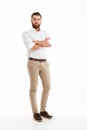 Serious young bearded man standing over white wall Royalty Free Stock Photo