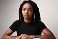 Serious young black woman wearing black t-shirt. Isolated over white background.