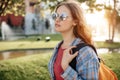 Serious young blonde hipster woman student with backpack at university.