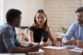 Serious young business lady discussing project with mixed race colleagues. Royalty Free Stock Photo