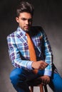 Serious young business man in checkered suit sitting