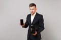 Serious young business man hold mobile phone with blank empty screen metal bank safe for money accumulation isolated on Royalty Free Stock Photo