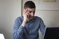 Serious young business man looking worried at laptop screen at home office Royalty Free Stock Photo