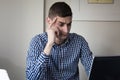 Serious young business man looking worried at laptop screen at home office Royalty Free Stock Photo