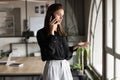 Serious young business woman talking on mobile phone in office Royalty Free Stock Photo