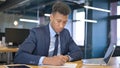 Serious Young Businessman doing Paperwork in Office Royalty Free Stock Photo