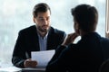 Serious young businessman holding job interview with applicant. Royalty Free Stock Photo