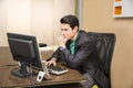 Serious young businessman sitting at desk in office Royalty Free Stock Photo