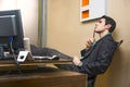 Serious young businessman sitting at desk in office thinking Royalty Free Stock Photo