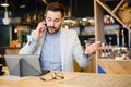 Serious young businessman talking on a phone, working in a cafe Royalty Free Stock Photo