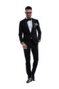 Serious young businessman in tuxedo holding hands in pocket