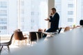 Serious young businessman wearing fashion suit is talking on mobile phone in modern office room Royalty Free Stock Photo