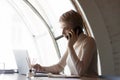 Serious young businesswoman discussing computer project presentation by phone call. Royalty Free Stock Photo