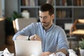 Worried male employee check time before deadline at workplace