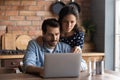 Serious young couple using laptop in cozy kitchen, browsing apps Royalty Free Stock Photo