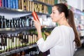 Serious young female choosing hair care products at cosmetics showroom Royalty Free Stock Photo