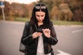 Serious young female traveler using smart phone while standing on the road Royalty Free Stock Photo