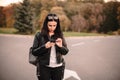 Serious young female traveler using smart phone while standing on the road Royalty Free Stock Photo