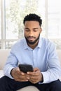 Serious young handsome Black man typing on mobile phone Royalty Free Stock Photo