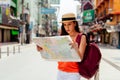 Young Hispanic brunette woman looking at map on vacation