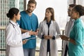 Serious young Indian doctor talking to medical diverse staff Royalty Free Stock Photo