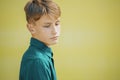 Serious young man in a blue shirt on a yellow background Royalty Free Stock Photo