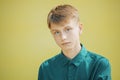 Serious young man in a blue shirt on a yellow background Royalty Free Stock Photo