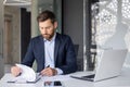 Serious young man businessman, company owner and executive director working at desk in office with documents, signing Royalty Free Stock Photo